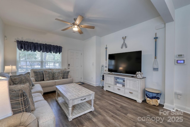 living area featuring baseboards, dark wood-type flooring, and ceiling fan