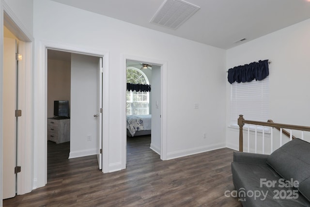 living area featuring visible vents, baseboards, and dark wood-style flooring