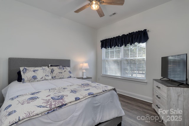 bedroom featuring visible vents, baseboards, dark wood-type flooring, and a ceiling fan