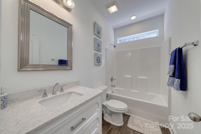 full bath featuring vanity, washtub / shower combination, toilet, and wood finished floors