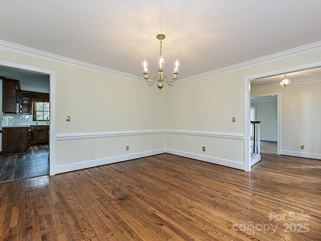 spare room featuring baseboards, a notable chandelier, ornamental molding, and dark wood-style flooring