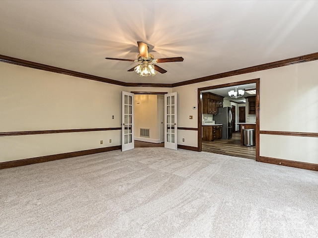 carpeted spare room with french doors, baseboards, visible vents, and ceiling fan with notable chandelier