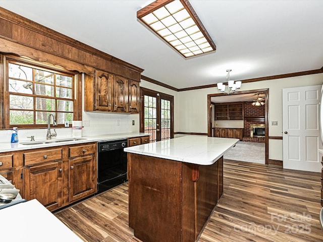 kitchen featuring a kitchen island, a sink, black dishwasher, french doors, and crown molding