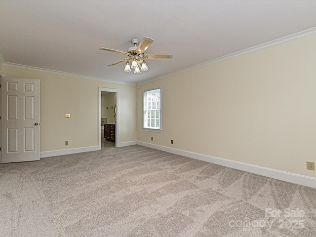 carpeted spare room with baseboards, ornamental molding, and a ceiling fan