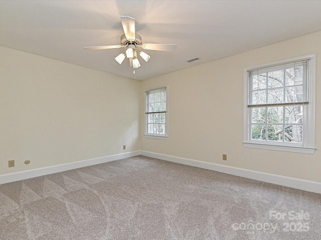 empty room featuring a ceiling fan, baseboards, visible vents, and light carpet