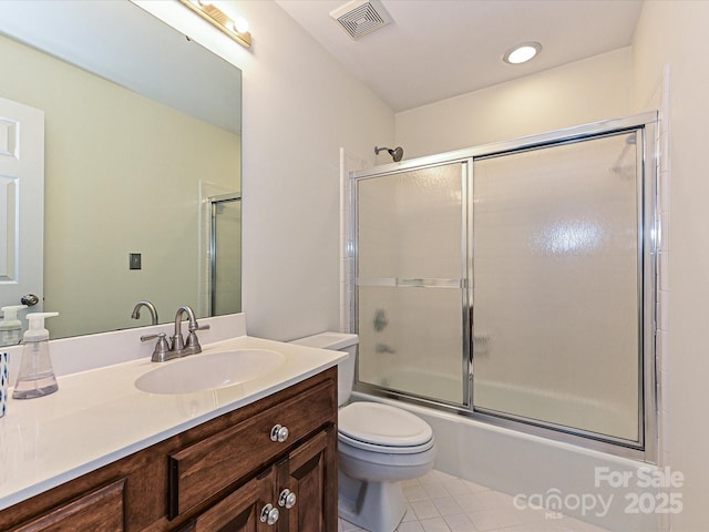 bathroom featuring vanity, visible vents, tile patterned flooring, toilet, and combined bath / shower with glass door