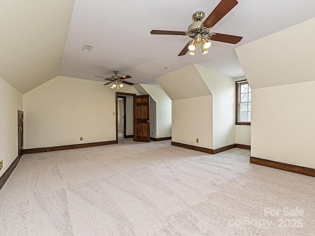 additional living space with a ceiling fan, light colored carpet, visible vents, and baseboards