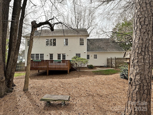 back of property with a wooden deck and fence