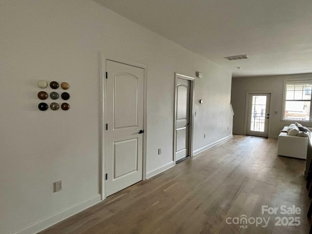 interior space featuring visible vents, baseboards, and wood finished floors