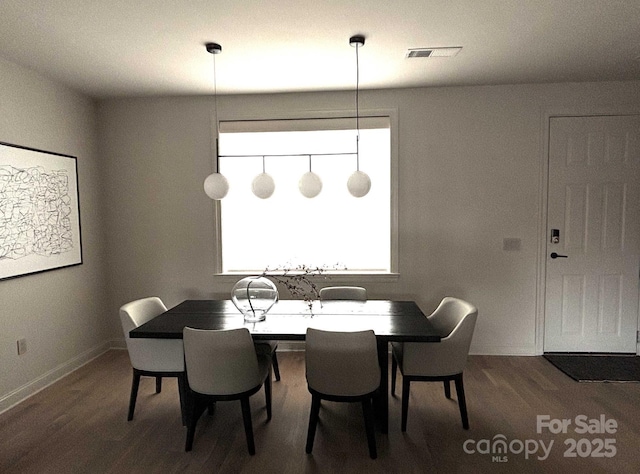 dining space with visible vents, baseboards, and wood finished floors