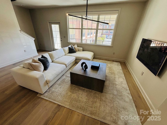 living area with baseboards and wood finished floors