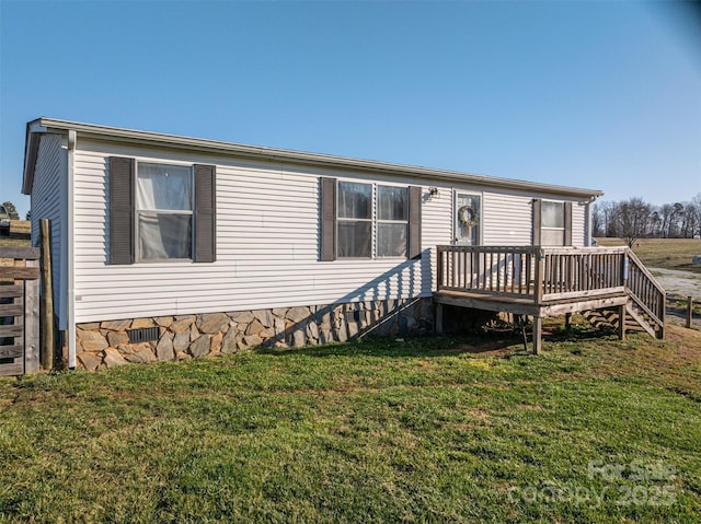 manufactured / mobile home featuring a deck and a front lawn