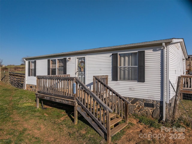 view of front of house with a deck, a front lawn, and crawl space