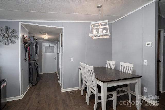 dining room with baseboards, stacked washer and dryer, an inviting chandelier, a textured ceiling, and dark wood-style flooring