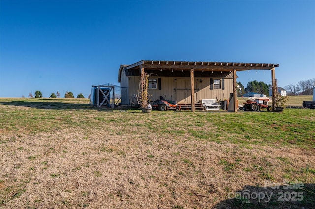 rear view of property with an outbuilding, an outdoor structure, and a lawn