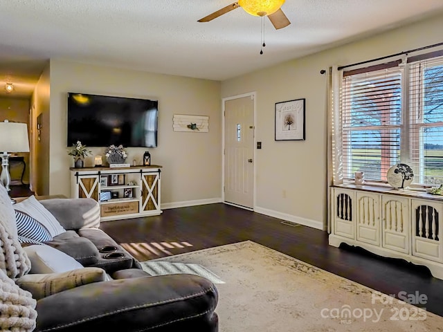 living room with baseboards, a ceiling fan, a textured ceiling, and wood finished floors