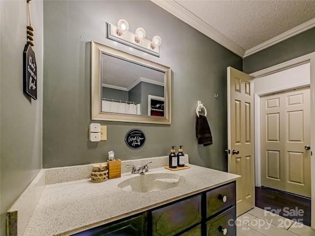 bathroom featuring a textured ceiling, ornamental molding, and vanity