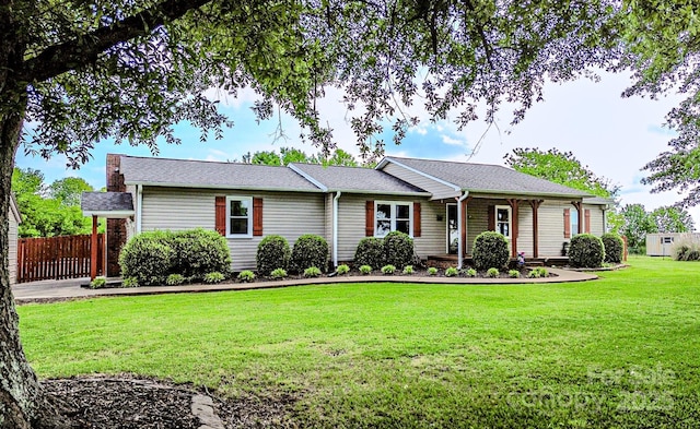 ranch-style house with fence and a front lawn