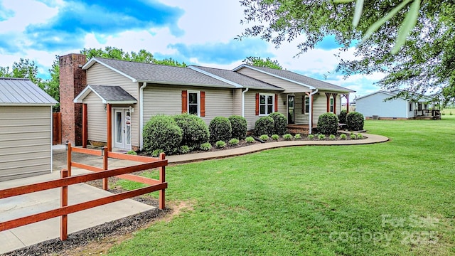 single story home featuring a shingled roof and a front lawn