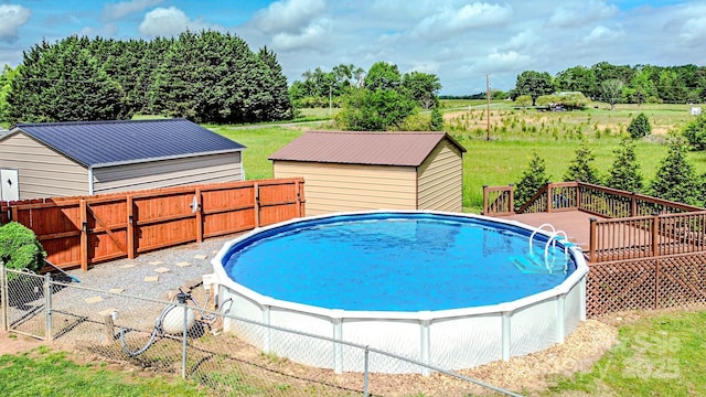 view of swimming pool with a fenced backyard, a gate, a fenced in pool, and a deck