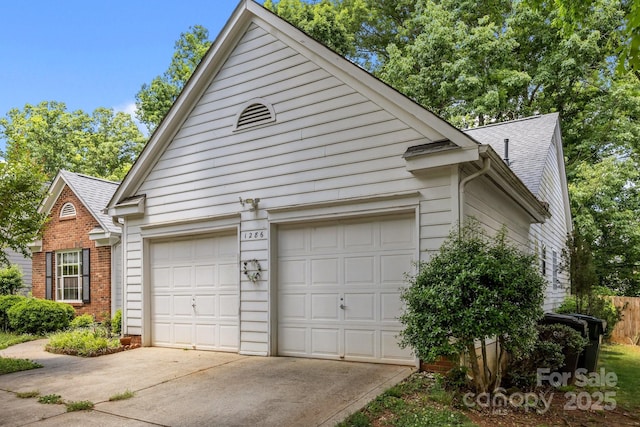 view of side of property featuring concrete driveway, a garage, a shingled roof, and brick siding