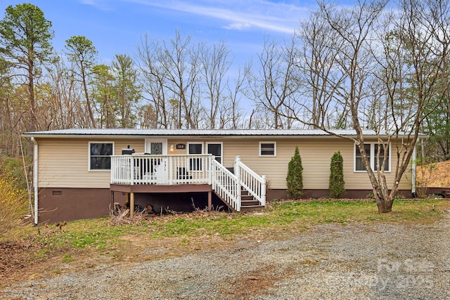 view of front of home featuring a wooden deck, metal roof, and crawl space