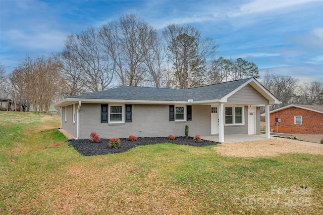 view of front of home with a front yard, brick siding, and a shingled roof