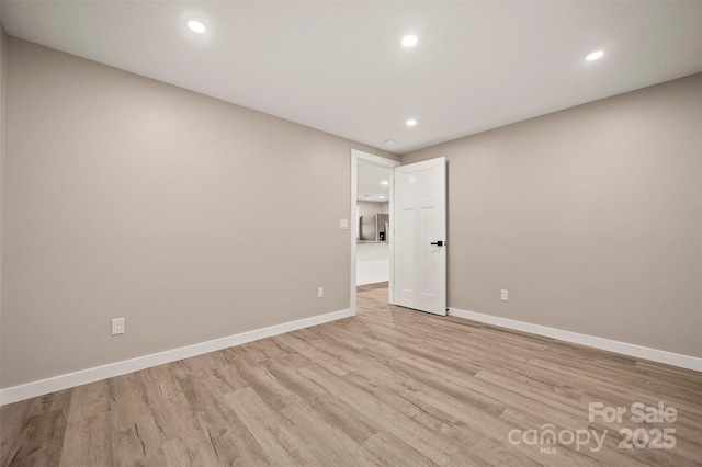 unfurnished room featuring recessed lighting, baseboards, and light wood-style flooring