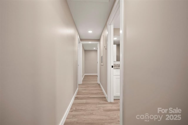 hall with baseboards and light wood-style floors