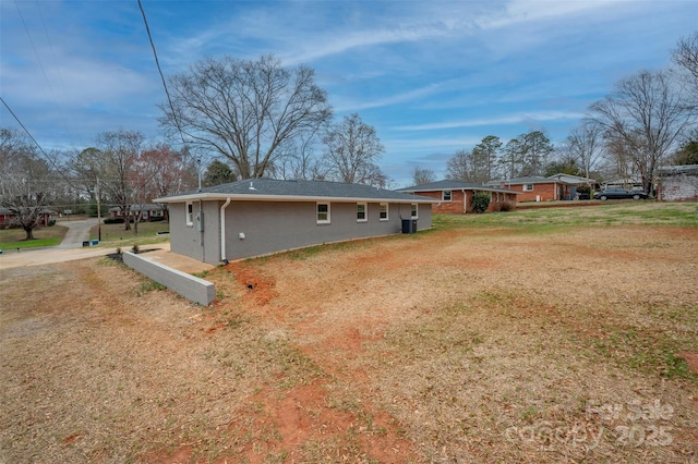 back of house featuring brick siding and a yard