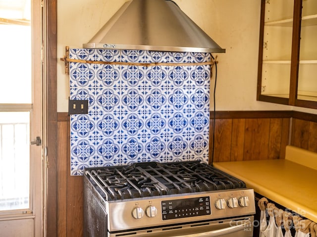 kitchen with wainscoting, light countertops, and stainless steel range with gas cooktop