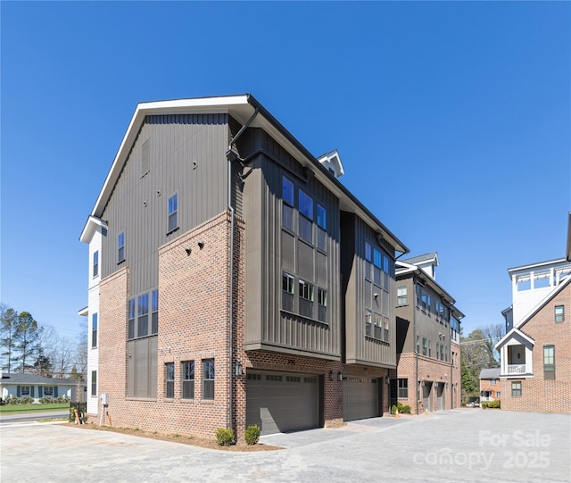 view of building exterior featuring driveway and an attached garage