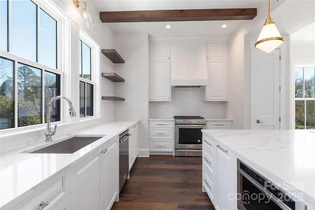 kitchen featuring premium range hood, beamed ceiling, a sink, white cabinetry, and stainless steel appliances