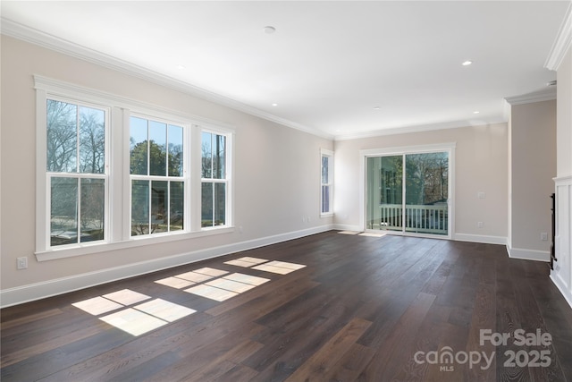 spare room with a healthy amount of sunlight, dark wood-type flooring, baseboards, and ornamental molding