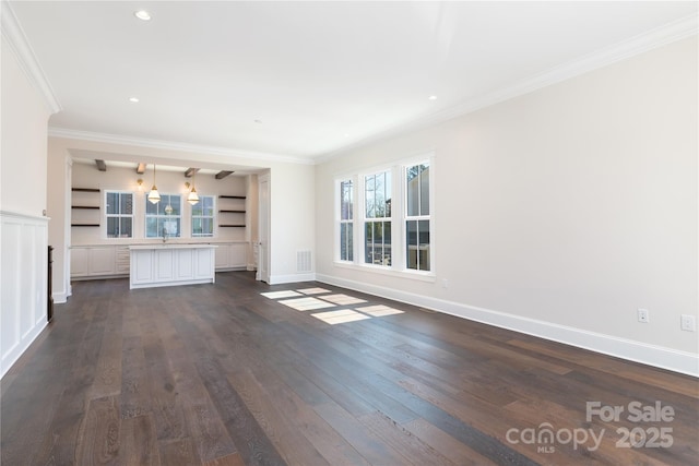 unfurnished living room with a wealth of natural light, visible vents, dark wood-type flooring, and ornamental molding