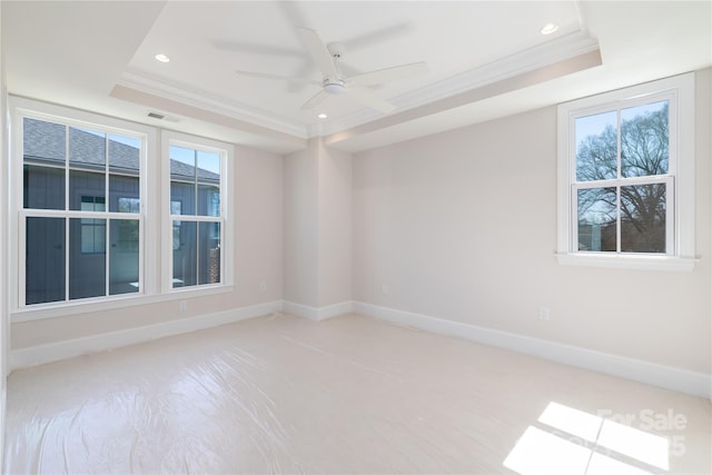 empty room featuring visible vents, crown molding, and a tray ceiling