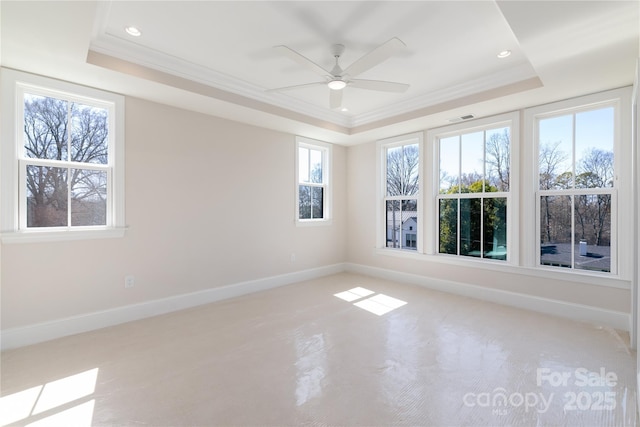 unfurnished room featuring a tray ceiling, baseboards, visible vents, and crown molding