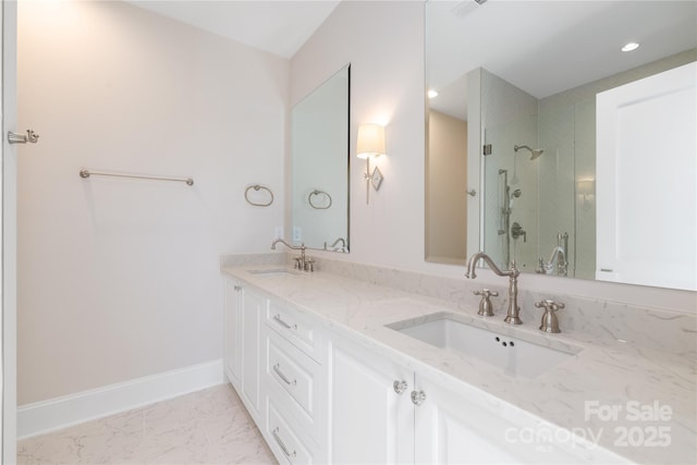 full bath with a sink, marble finish floor, a shower stall, and double vanity