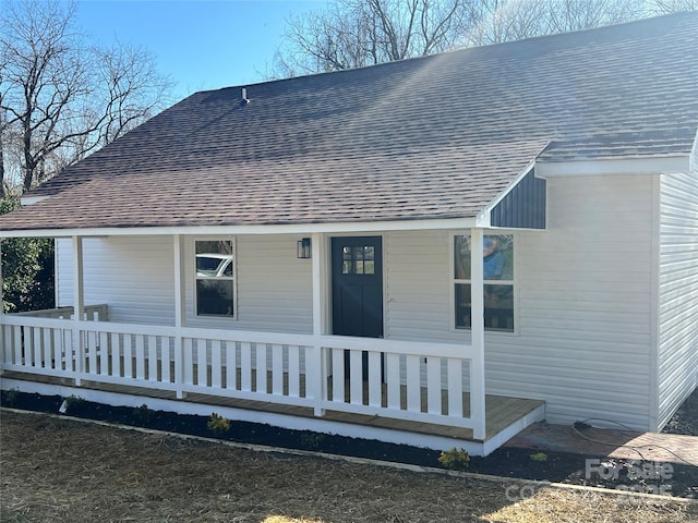 exterior space with a porch and a shingled roof