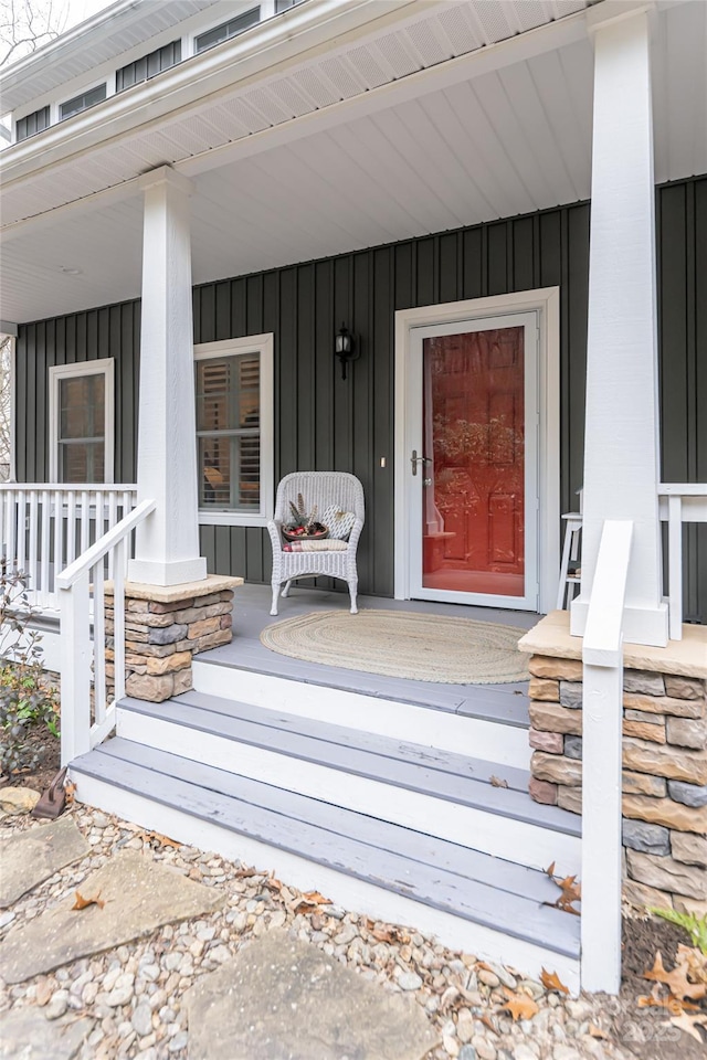 property entrance featuring covered porch and board and batten siding