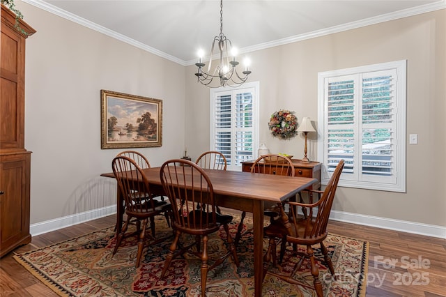 dining area with an inviting chandelier, crown molding, baseboards, and dark wood-type flooring