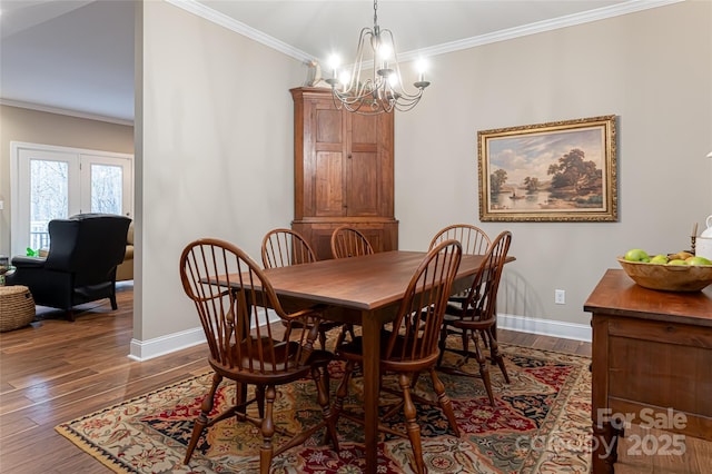 dining room with dark wood-style flooring, an inviting chandelier, and ornamental molding