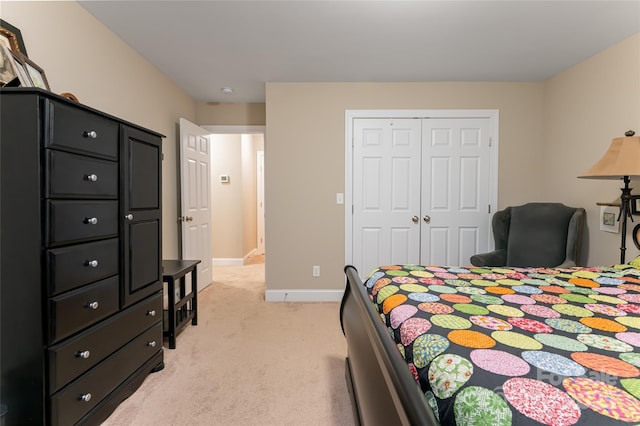 bedroom featuring baseboards, a closet, and light carpet