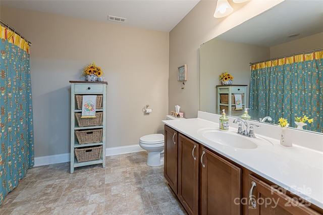 bathroom with vanity, toilet, baseboards, and visible vents