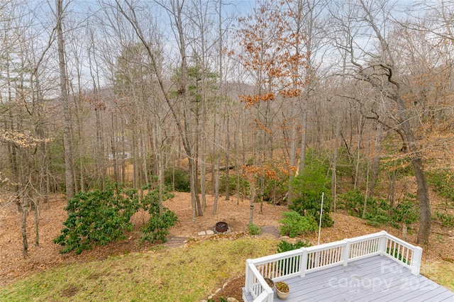 view of yard with a view of trees and a wooden deck