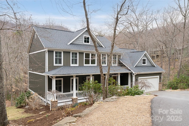 view of front of property featuring a porch, a shingled roof, a garage, aphalt driveway, and board and batten siding