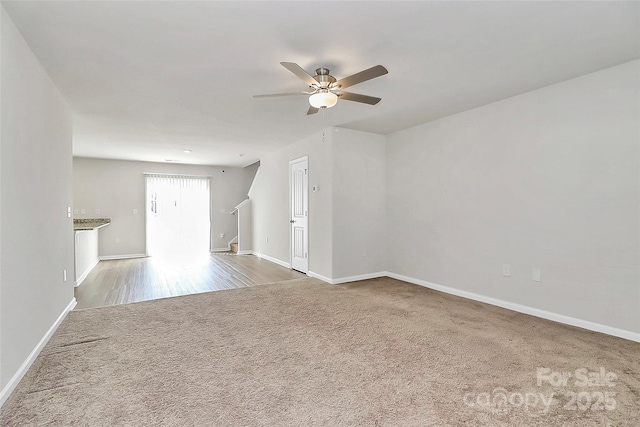 unfurnished living room with a ceiling fan, baseboards, and carpet floors