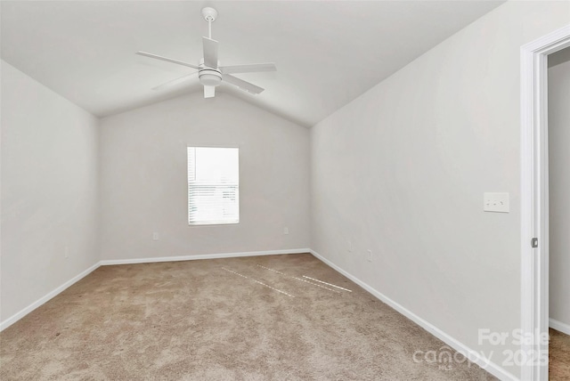 spare room featuring carpet flooring, baseboards, a ceiling fan, and vaulted ceiling