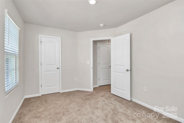 unfurnished bedroom featuring carpet flooring and baseboards