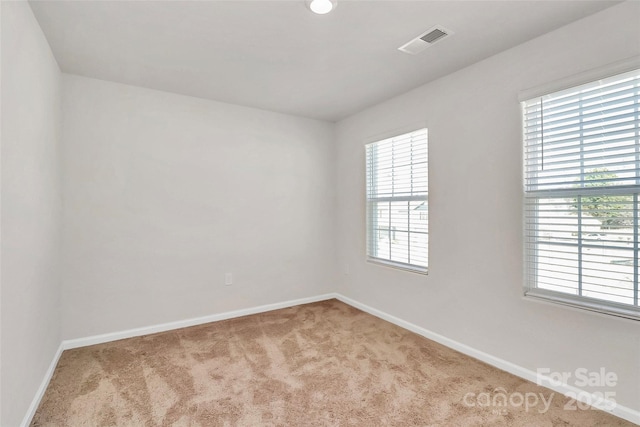 carpeted spare room with baseboards and visible vents